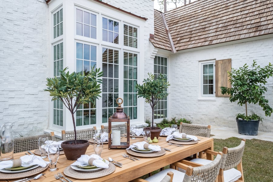 courtyard outdoor dining area of a classic stone home with stunning windows with grilles